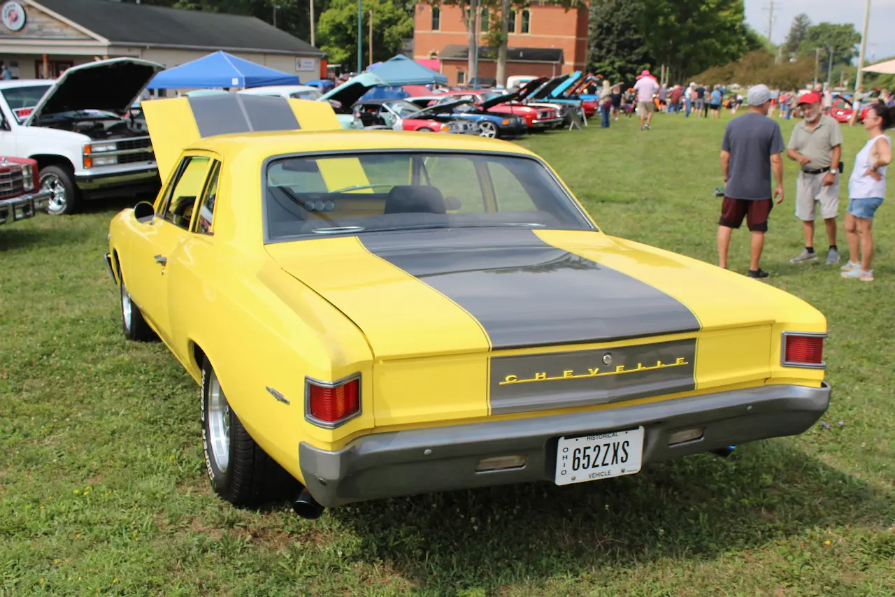 1960s Chevrolet muscle car, yellow and black, rear three-quarter view
